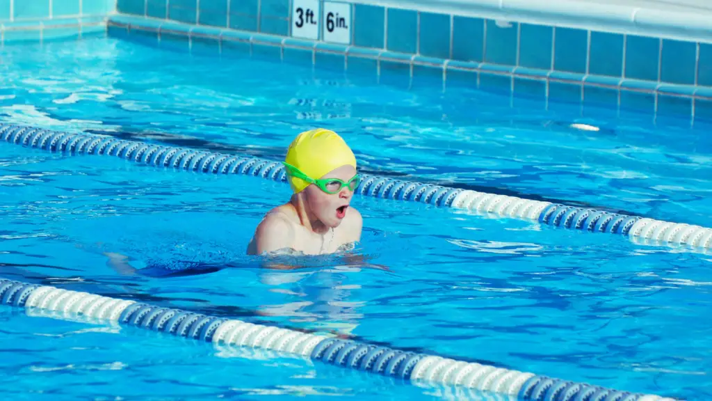 A young swimmer is swimming in a pool.